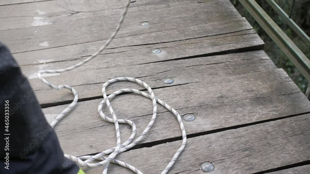 detail shot of safety rope unraveling while firefighter descends from bridge, slowmo detail shot of safety rope unraveling while firefighter descends from bridge, slowmo