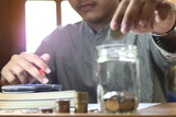 businessman holding coins putting in glass. concept saving money for finance accounting.