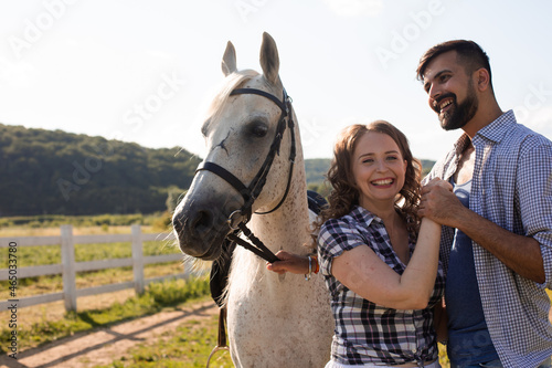 The happy woman with her sweetheart stand next to a horse