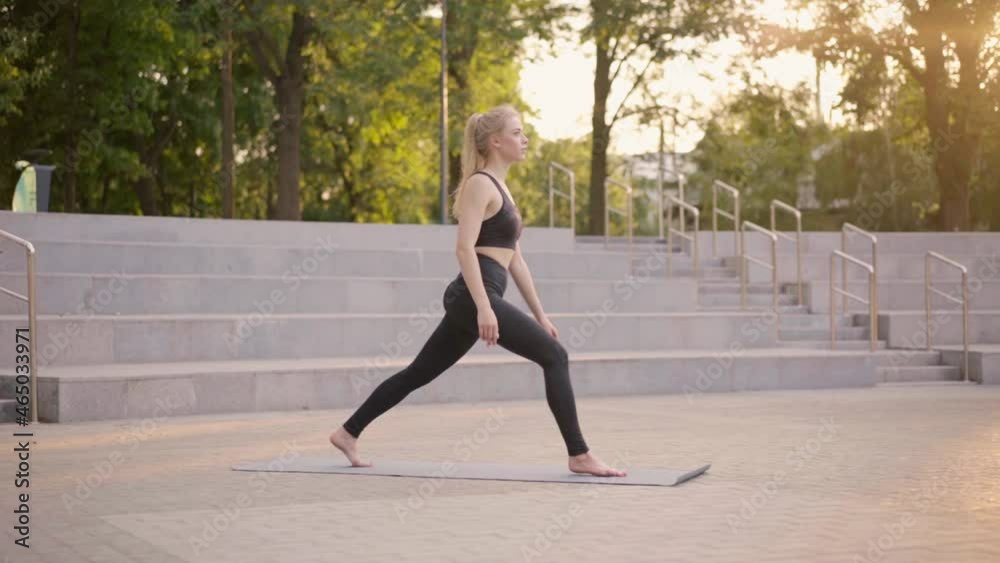 Fitness Woman Practice Yoga Exercises On Mat Outdoor City Street Sunlight Background Caucasian Female 25 years old Relaxing On Fitness Mat Dressed Sportswear Healthy Lifestyle concept Virabhadrasana