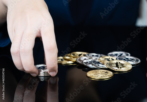 Woman holding some pieces of golden Bitcoin token