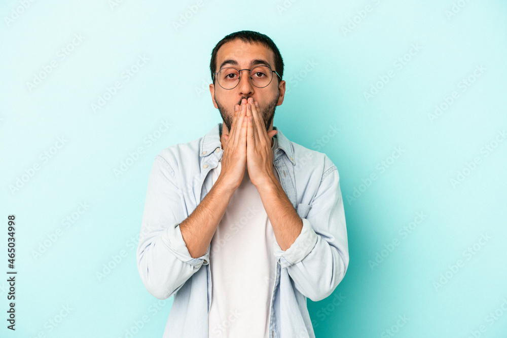 Young caucasian man isolated on blue background shocked covering mouth with hands. Young caucasian man isolated on blue background shocked covering mouth with hands.