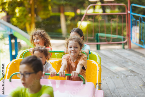 The happy kids on a roller coaster in the amusement park