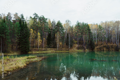 Autumn lake in the middle of forest. Rustic autumn landscape.