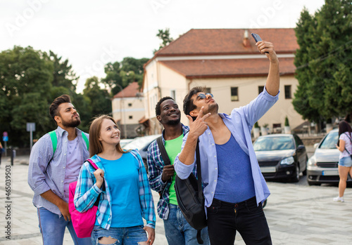 The joyful group of multiethnic students taking a selfie outdoors