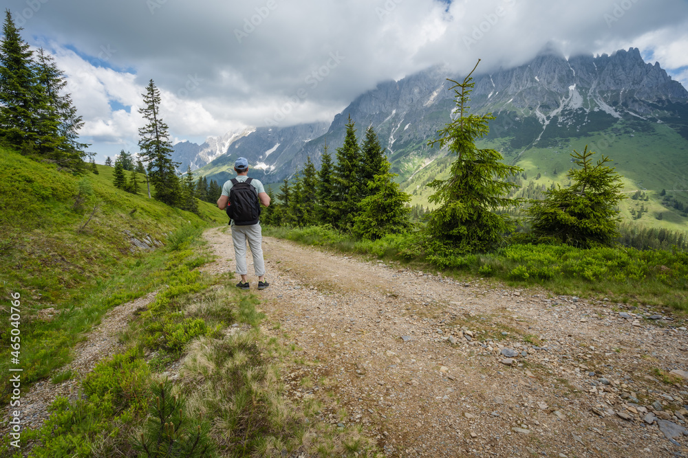 Traveler man on hiking trail enjoying Wilder Kaiser mountains, Tirol - Austria