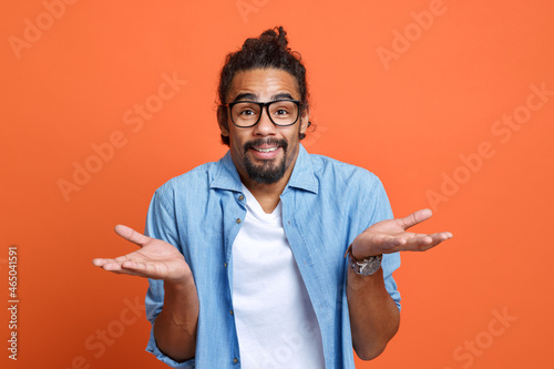 Young doubtful confused african american man spreading palms, saying i don't know