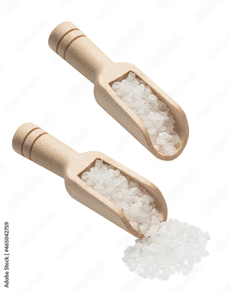 Sea salt poured from wooden scoop isolated on white