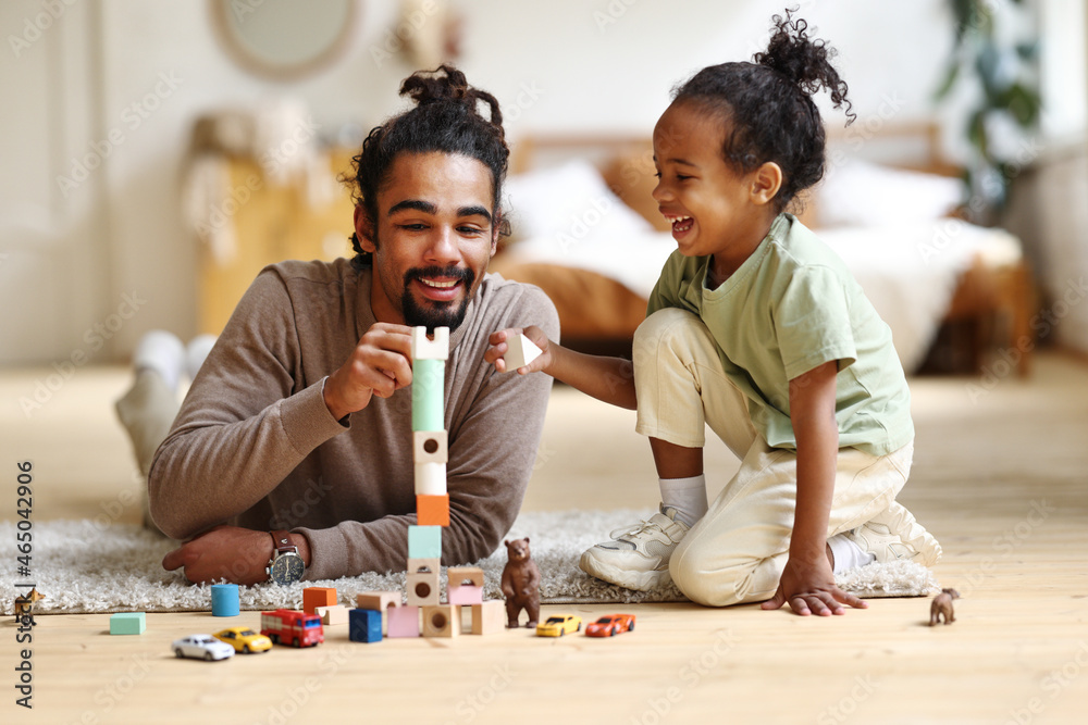 © JenkoAtaman - Happy african american family father and child son laughing while playing toys together at home © JenkoAtaman - Happy african american family father and child son laughing while playing toys together at home