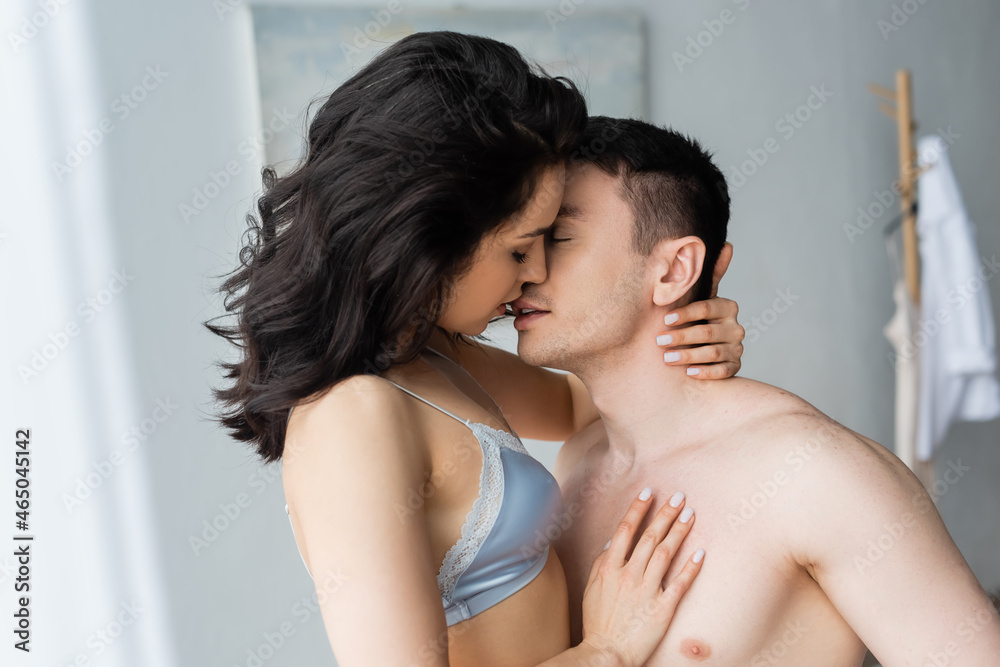 sexy young woman in bra kissing shirtless boyfriend sexy young woman in bra kissing shirtless boyfriend