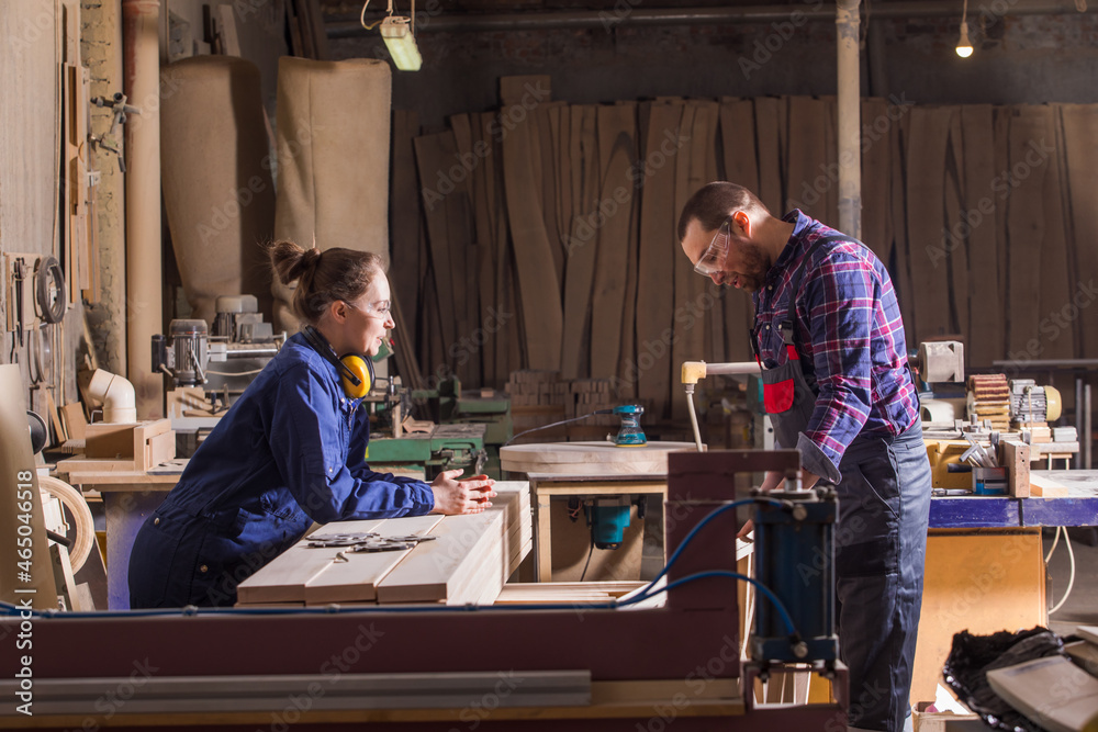 Female carpenter focused on measuring wood plank Female carpenter focused on measuring wood plank
