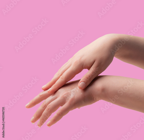 Female hands and moisturizing cream on white background