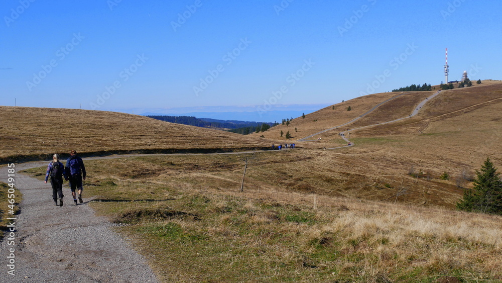 junges Wanderpaar auf dem Feldbergsteig in Richtung Feldberggipfel und Wetterstation junges Wanderpaar auf dem Feldbergsteig in Richtung Feldberggipfel und Wetterstation
