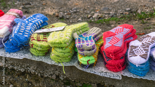 Handmade knitted products for children made of natural wool. Warm knitted things for winter. Knitted wool socks for children. The market of knitted things. Street market.