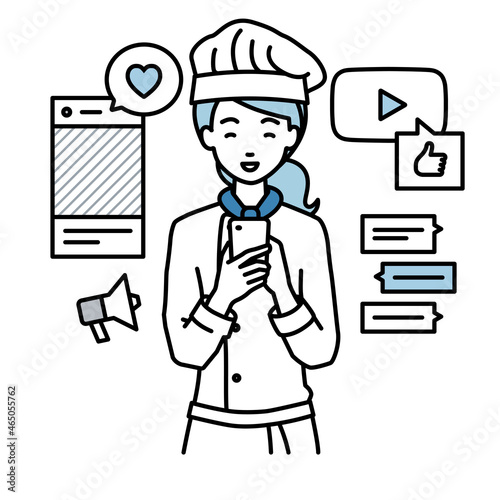 立ってスマートフォンでさまざまなSNSで楽しく交流する調理師の女性