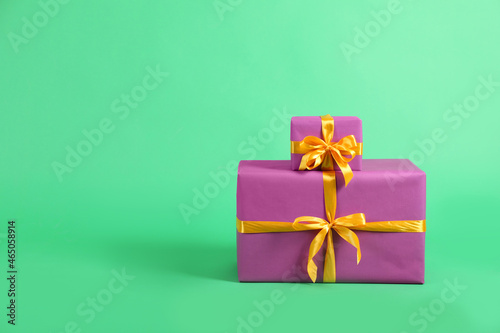 Beautifully wrapped gift boxes on green background. Space for text