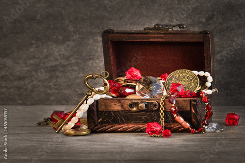 pirate treasure background, gems, gold, pearls, coins and jewelry in an old wooden chest with an open lid, vintage key, concept of wealth, inheritance, inflation,