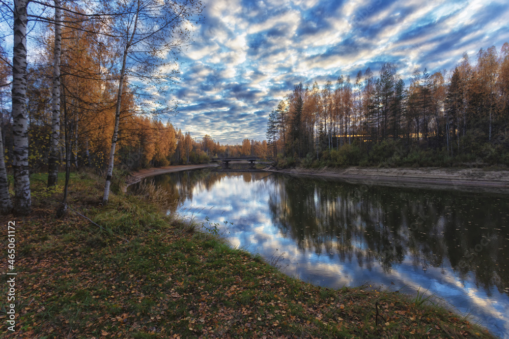 Beautiful river Renya in Tver region, Russia at sunset of the day. Beautiful reflection of clouds. Autumn photography. Blurred focus.