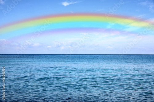 Beautiful rainbow in blue sky over sea on sunny day © New Africa