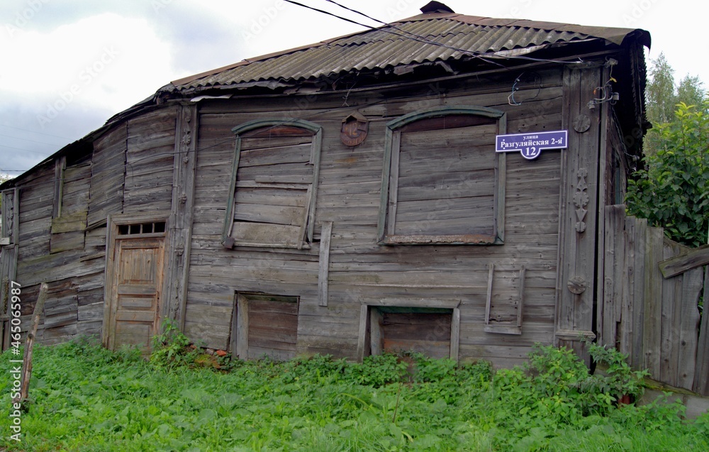 An old dilapidated dark house of the 19th century. Boarded up windows with boards in an old wooden house. An old dilapidated dark house of the 19th century. Boarded up windows with boards in an old wooden house.