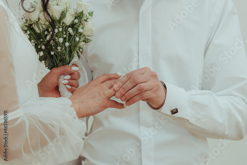 Wedding hands of a bride and groom. He puts on a wedding ring