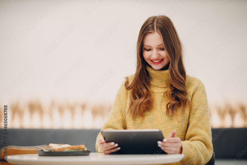 Beautiful young woman using digital tablet at cafe table with cup of coffee online shopping Beautiful young woman using digital tablet at cafe table with cup of coffee online shopping