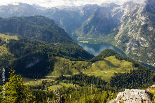 Beautiful lake Königssee in the valley of the mountains with clouds passing by berchtesgaden National Park, Germany, close to the border of Austria photo