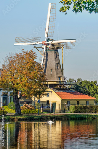 Rotterdam, The Netherlands, October 24, 2021: one of the windmills at lake Kralingse Plas reflects in a nearby pond on a sunny day in autumn photo