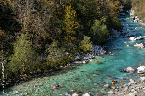  kayakers paddling on the clear turquoise waters of the Soca River in the mountains of northern Slovenia