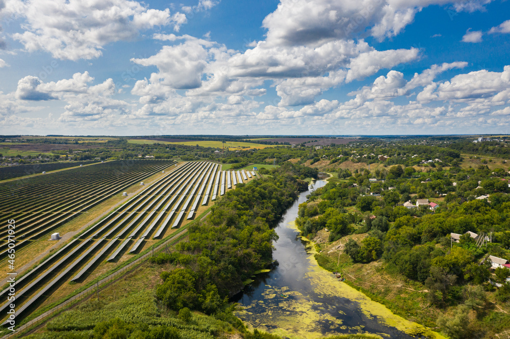 Aerial view of the Solar panels on a hill above the river in Kamianka, Ukraine