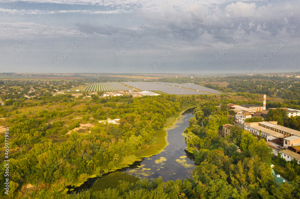 The tyasmin river on the background of the solar panels, view from a drone
