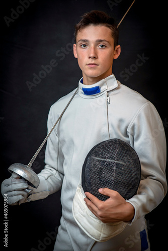 A young swordsman in ammunition and with a sword in his hand