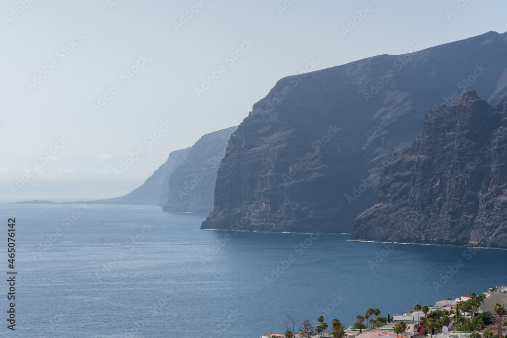 View of the Atlantic Ocean and the cliffs of Los Gigantes. The town of Puerto de Santiago is located on the coast. View from the observation deck - Mirador Archipenque. Tenerife. Canary Islands. Spain