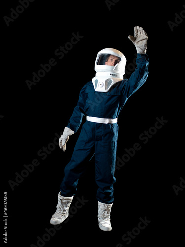 An astronaut in weightlessness reaches up with his hand. The hero of the science fiction story is a pioneer of space exploration. A young man in a space suit