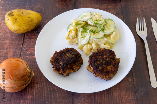 German meatballs called Frikadellen served with cucumber potato salad