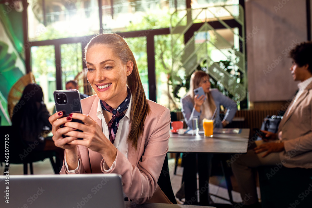 Business woman working at cafe using laptop and smartphone. Business woman working at cafe using laptop and smartphone.