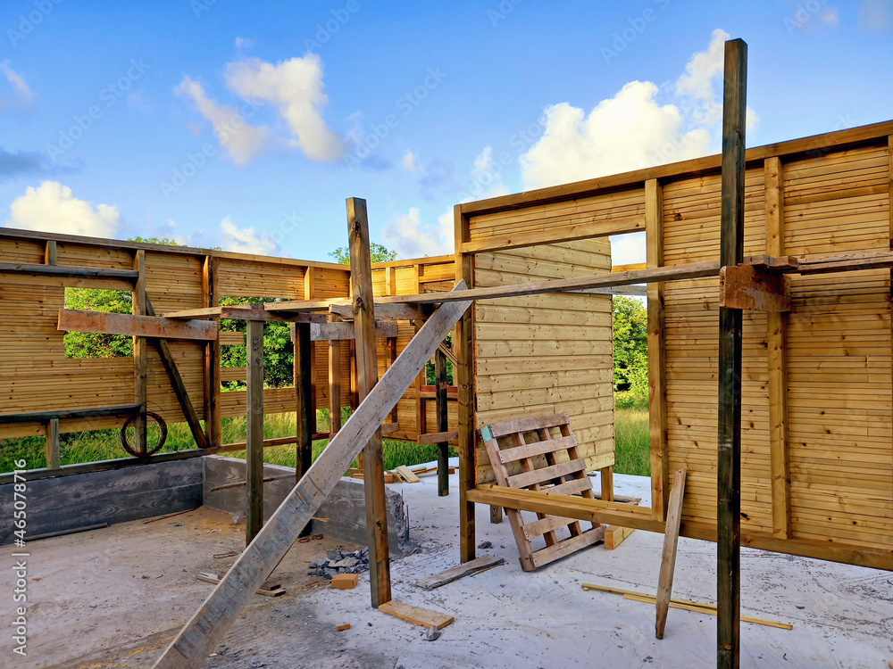 Construction detail of an ecological house with recycled materials and a wooden facade. Sustainable house construction frame under tropical blue sky. Architecture and construction in French Antilles