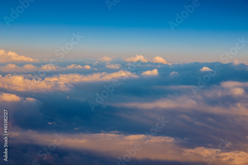 Sunny sky abstract background, beautiful cloudscape, on the heaven, view over white fluffy clouds, freedom concept. Aerial view of sky and white clouds. View from airplane.