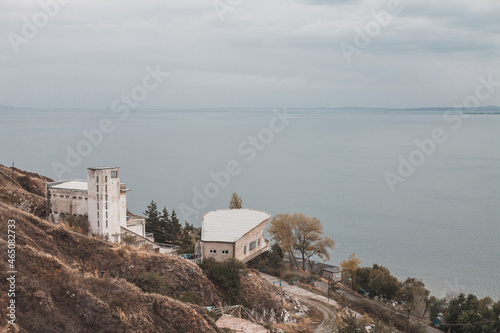 Scenic views of the sea and mountains from the cliff. Nice view of the bay. Cloudy sky and blue sea. Residential buildings stand on a cliff by the sea © Aleksandr