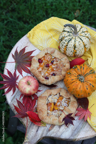 Mini pumpkin pies on a table. Top view photo with autumn pastry and seasonal vegetables. Food still life photo. 