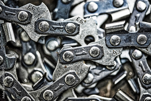 Metal chainsaw chain with sharp teeth close-up with blurred background