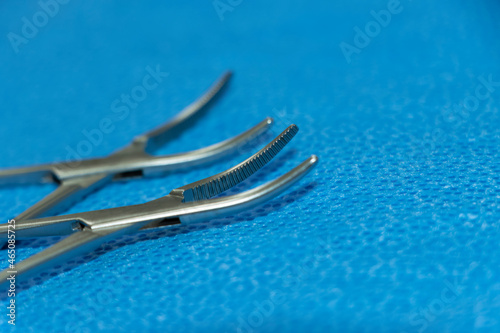 Hemostats Artery Forceps Tip In Blue Background. Selective Focus