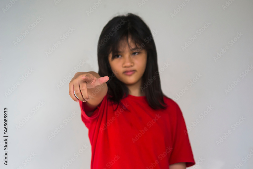 A young beautiful girl pointing with her index finger. A young beautiful girl pointing with her index finger.