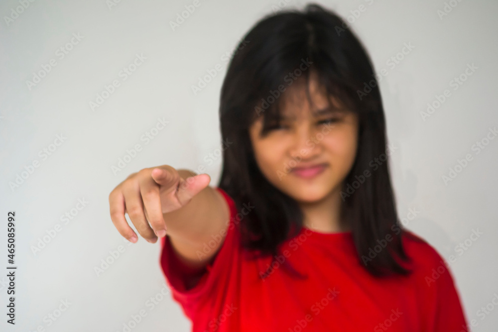 A young beautiful girl pointing with her index finger. A young beautiful girl pointing with her index finger.