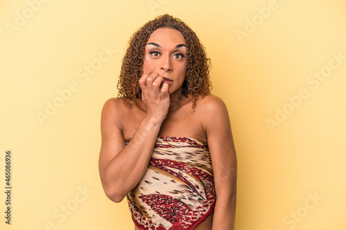 Young latin transsexual woman isolated on yellow background biting fingernails  nervous and very anxious.