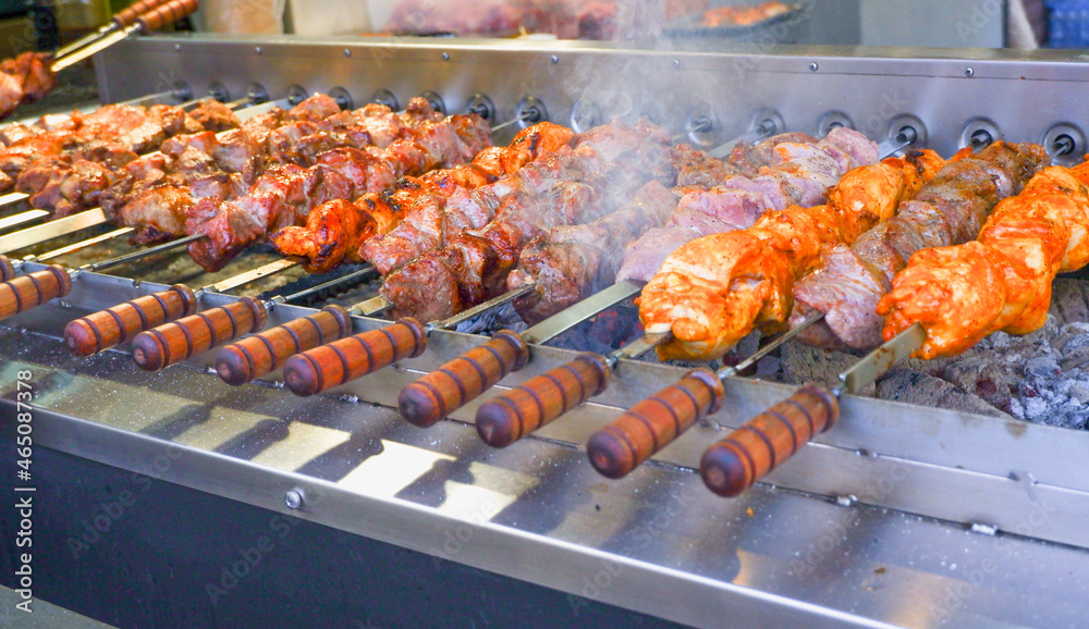 Street food. Automatic stainless steel grill grills skewers on skewers. Fried meat. Cooking street food.
