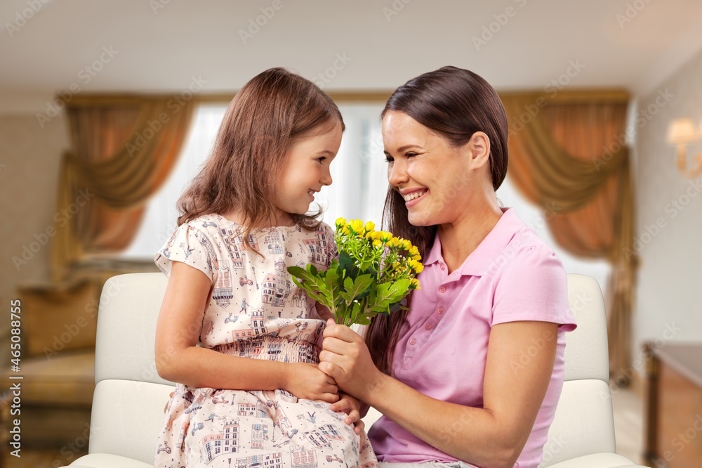 Loving little child hugging happy mom and greeting with a bouquet Loving little child hugging happy mom and greeting with a bouquet