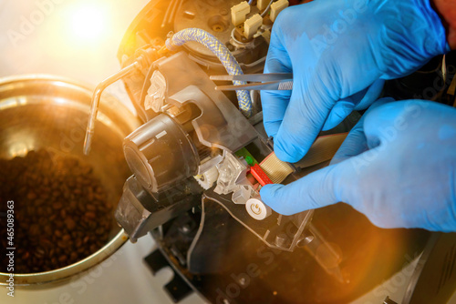 A repairman repairs a broken coffee maker
