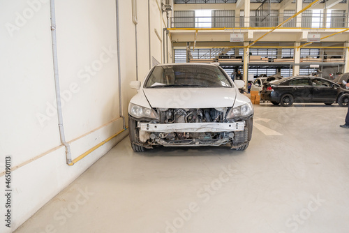 Broken car in auto repair service workshop