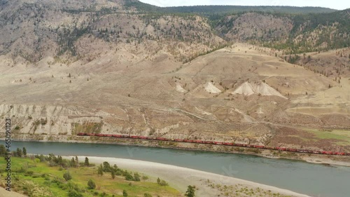 Unique, elevated perspective view of the panorama of Thompson river at between Spences Bridge and Ashcroft. A cargo train is serpentine following the river. photo